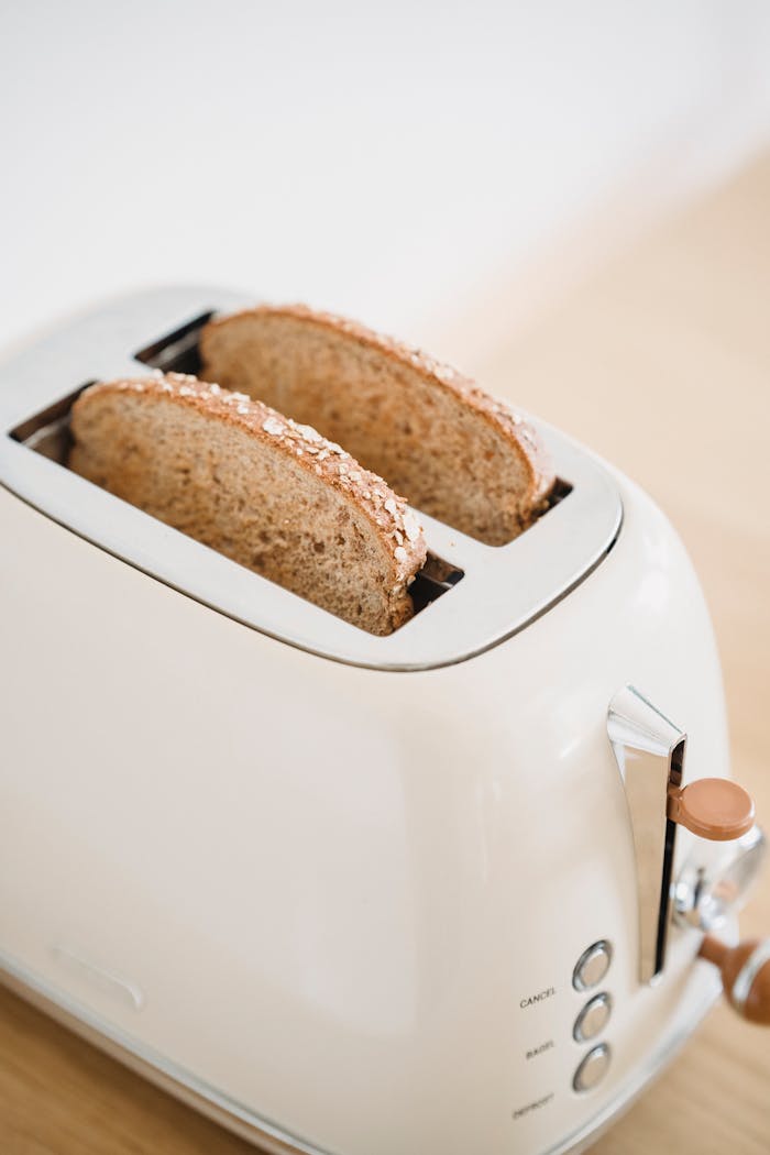 about-us Close-up of whole grain bread slices in a vintage toaster, perfect for breakfast themes.